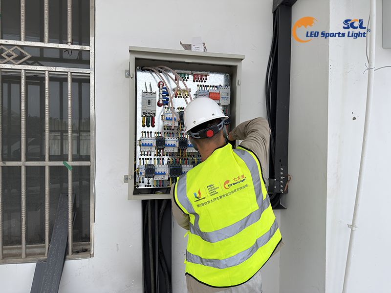 Engineer debugging intelligent electrical control box for stadium LED lighting zoning control system Engineer debugging intelligent electrical control box for stadium LED lighting zoning control system